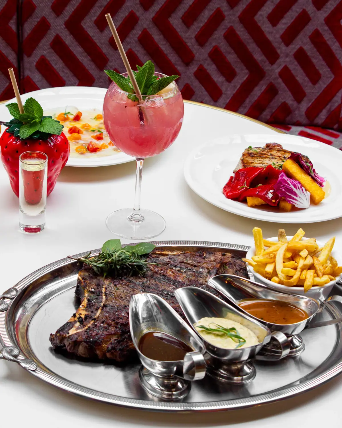 Large rib of beef to share, with fries, sauces and cocktails.