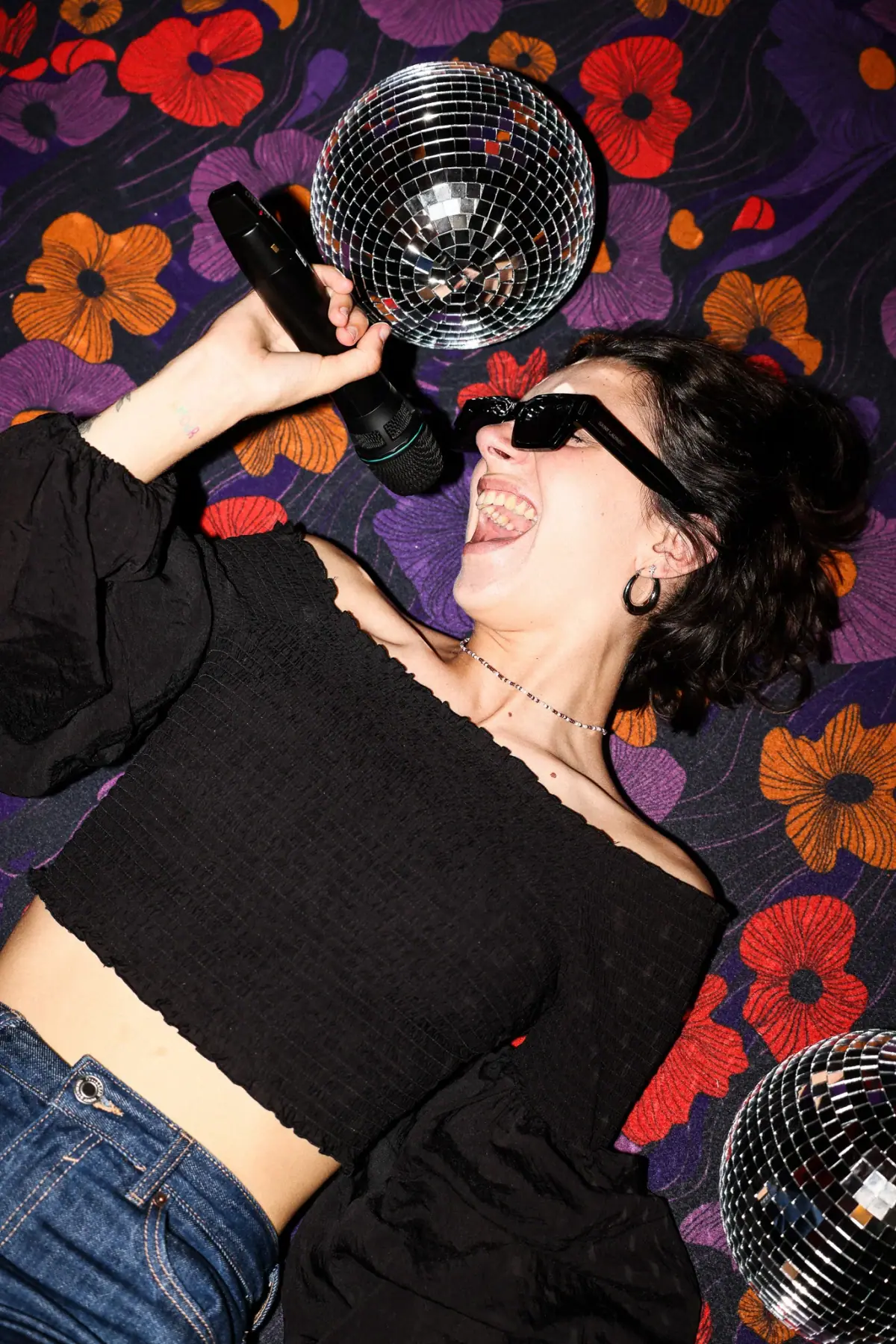 Woman singing karaoke under a disco ball at Madame Claude near Châtelet