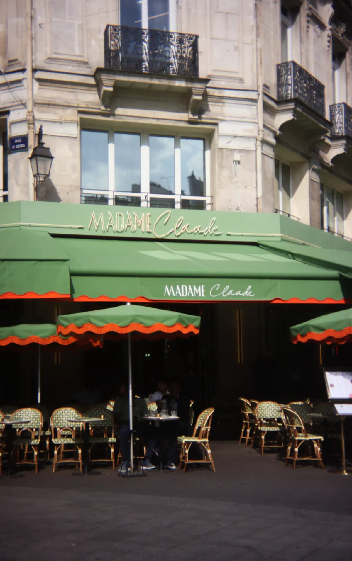 Exterior of Madame Claude restaurant, 2 rue Berger, Paris 1st, with its green terrace and retro neon sign