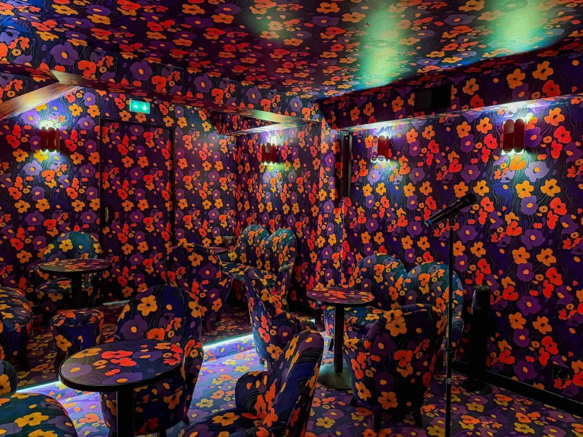 Customizable private karaoke room with floral patterns, neon lights and vintage 1970s style